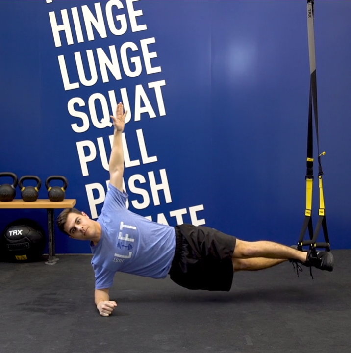 Image description: A young man demonstrating a TRX Plank rotation